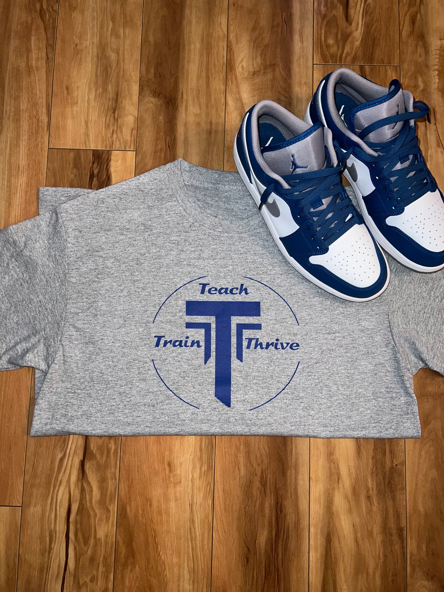 Grey T-shirts with our teach-train-thrive logo